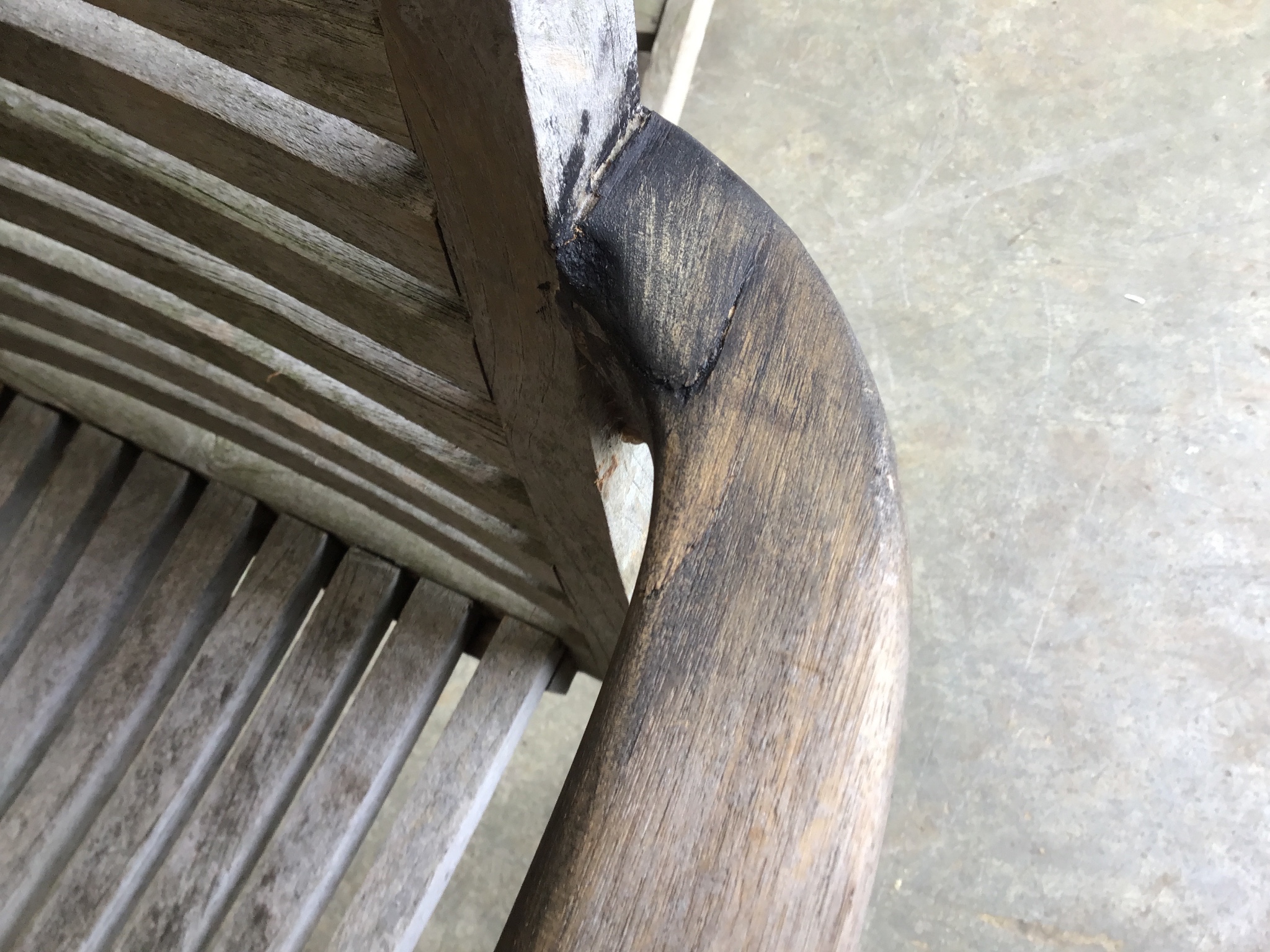 A weathered teak oval extending garden table, 242 cm extended, width 102 cm, height 73 cm and six stacking elbow chairs.